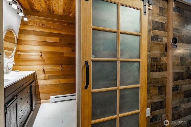 14001 Welcome Rd, Glacier, WA 98244 - bathroom with baseboard heating, wooden walls, double vanity, wooden ceiling, and tile patterned floors