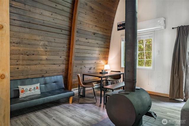 14001 Welcome Rd, Glacier, WA 98244 - living area featuring wood finished floors, wood walls, an AC wall unit, and a wood stove