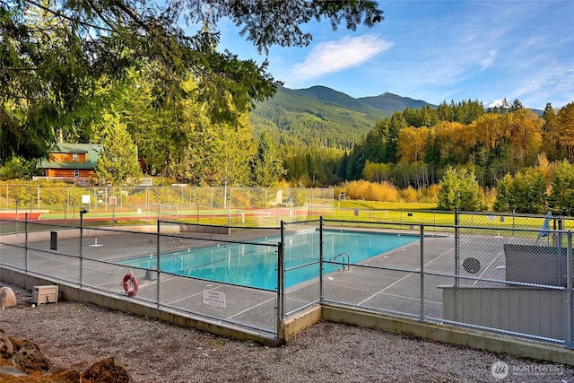 14001 Welcome Rd, Glacier, WA 98244 - view of swimming pool with a mountain view, a tennis court, and a forest view