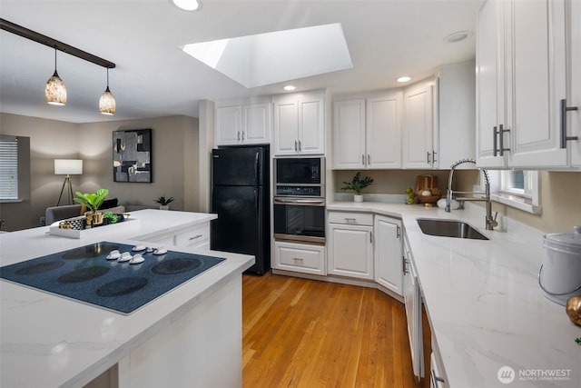 14715 57th Ave S, Tukwila, WA 98168 - kitchen featuring black appliances, white cabinets, a skylight, and recessed lighting