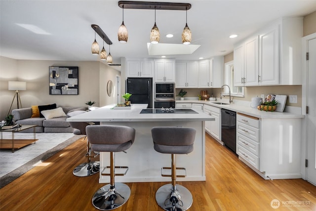 14715 57th Ave S, Tukwila, WA 98168 - kitchen with black appliances, a breakfast bar, white cabinetry, light countertops, and recessed lighting