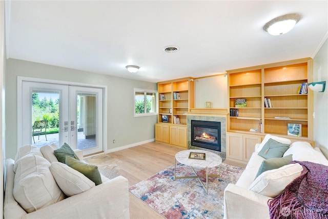 7001 Palm Ln, Anacortes, WA 98221 - living room with french doors, a tile fireplace, and light wood-style floors