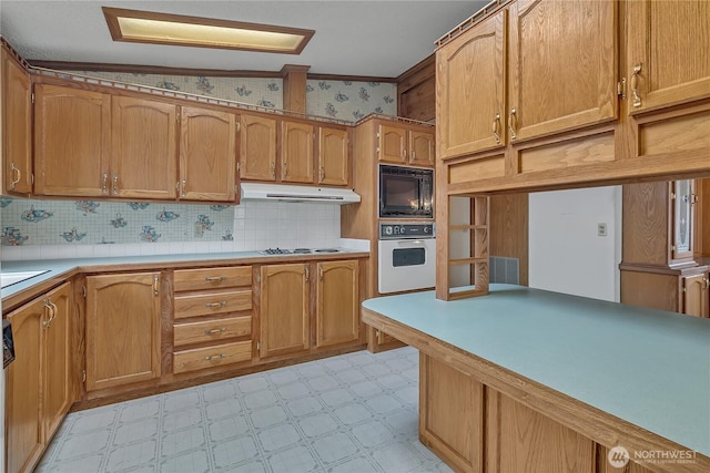 206 Noble Fir Cir, Enumclaw, WA 98022 - kitchen featuring oven, black microwave, light flooring, under cabinet range hood, and light countertops