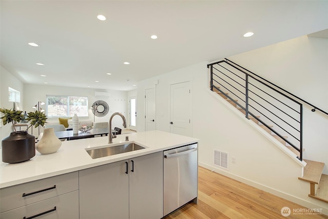2904 W Bertona St, Seattle, WA 98199 - kitchen with stainless steel dishwasher, recessed lighting, light countertops, a wall mounted AC, and light wood-style floors