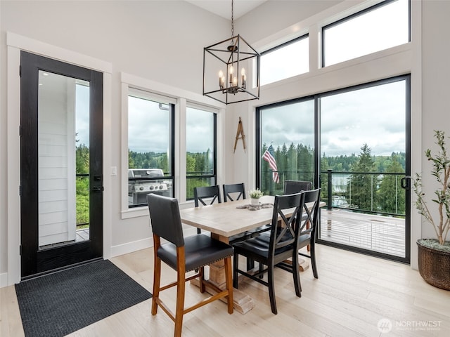 168 Lakeside Dr, Mossyrock, WA 98564 - dining area with a chandelier, healthy amount of natural light, light wood-type flooring, and a towering ceiling