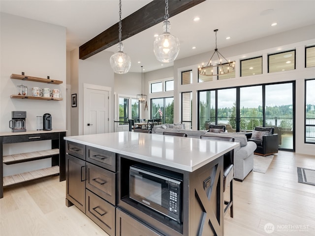 168 Lakeside Dr, Mossyrock, WA 98564 - kitchen with black microwave, a chandelier, light countertops, light wood-style floors, and beam ceiling