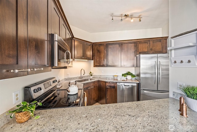 2360 43rd Ave E Unit 404, Seattle, WA 98112 - kitchen featuring appliances with stainless steel finishes, light stone counters, and dark brown cabinetry