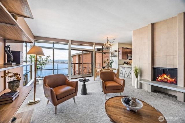 2360 43rd Ave E Unit 404, Seattle, WA 98112 - carpeted living room with a fireplace, a chandelier, a water view, and expansive windows