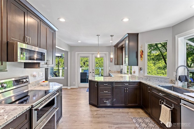 13233 59th Ave W, Edmonds, WA 98026 - kitchen featuring appliances with stainless steel finishes, dark brown cabinetry, a peninsula, healthy amount of natural light, and recessed lighting