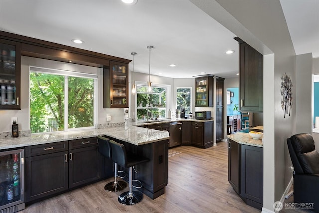 13233 59th Ave W, Edmonds, WA 98026 - kitchen with beverage cooler, a peninsula, light wood-style floors, stainless steel dishwasher, and light stone counters