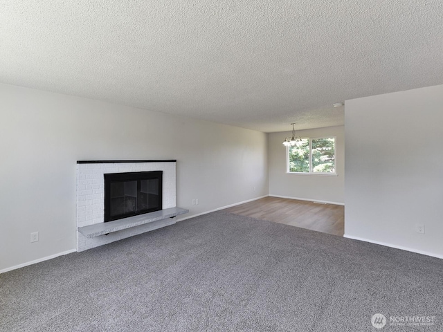 1501 154th St E, Tacoma, WA 98445 - unfurnished living room featuring a chandelier, carpet, a brick fireplace, and a textured ceiling