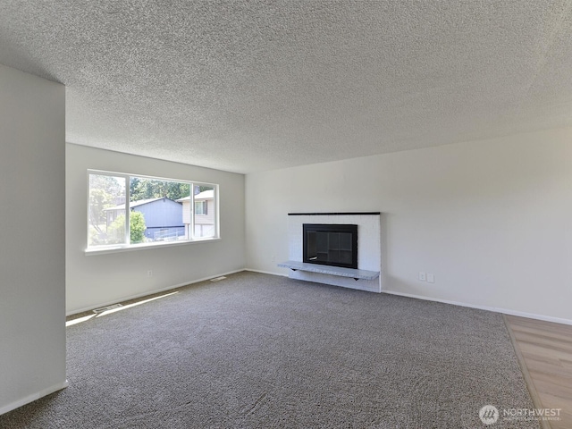 1501 154th St E, Tacoma, WA 98445 - unfurnished living room with a glass covered fireplace, a textured ceiling, and carpet flooring
