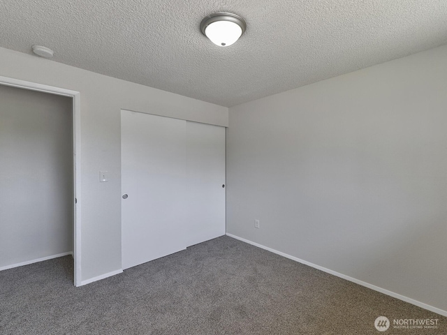 1501 154th St E, Tacoma, WA 98445 - unfurnished bedroom featuring dark carpet, a closet, and a textured ceiling