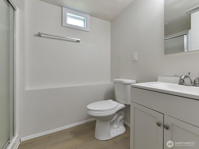 1501 154th St E, Tacoma, WA 98445 - full bath with wood finished floors, vanity, a shower with shower door, and a textured ceiling
