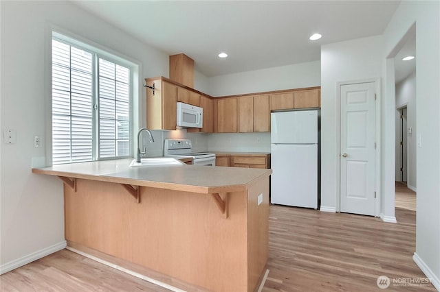 8415 15th Ave SE, Olympia, WA 98513 - kitchen with white appliances, a peninsula, light countertops, light wood finished floors, and recessed lighting