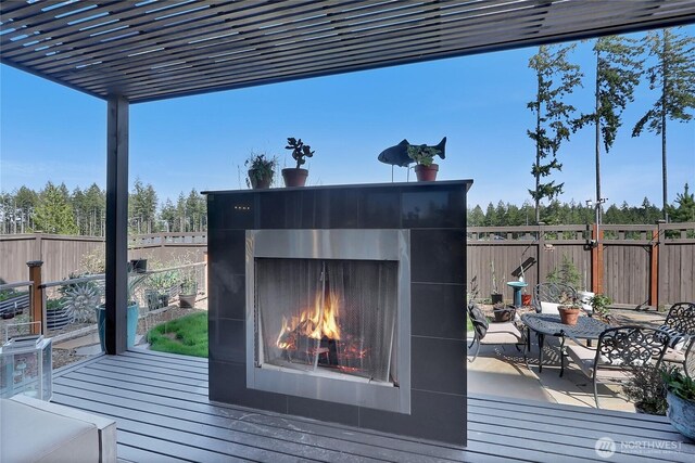 4615 SW Olivine Dr SW, Port Orchard, WA 98367 - wooden deck featuring a warm lit fireplace and a fenced backyard
