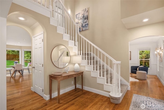 7089 NE Bay Hill Rd, Bainbridge Island, WA 98110 - stairs featuring arched walkways, wood finished floors, plenty of natural light, a towering ceiling, and recessed lighting
