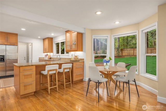 7089 NE Bay Hill Rd, Bainbridge Island, WA 98110 - kitchen featuring stainless steel built in refrigerator, plenty of natural light, light wood-type flooring, a breakfast bar, and recessed lighting