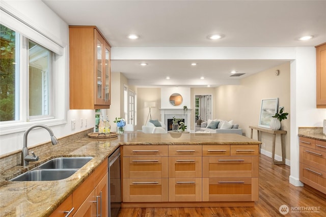7089 NE Bay Hill Rd, Bainbridge Island, WA 98110 - kitchen featuring stainless steel dishwasher, a peninsula, open floor plan, glass insert cabinets, and wood finished floors