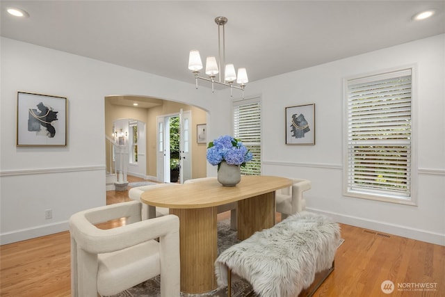 7089 NE Bay Hill Rd, Bainbridge Island, WA 98110 - dining space featuring arched walkways, light wood finished floors, recessed lighting, and a chandelier
