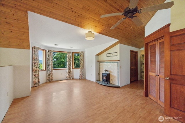 7554 Guemes Island Rd, Anacortes, WA 98221 - unfurnished living room featuring a wood stove, light wood-style flooring, a ceiling fan, vaulted ceiling, and wooden ceiling