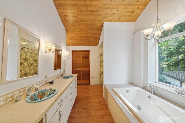 7554 Guemes Island Rd, Anacortes, WA 98221 - bathroom featuring lofted ceiling, a chandelier, double vanity, wood ceiling, and a tub with jets
