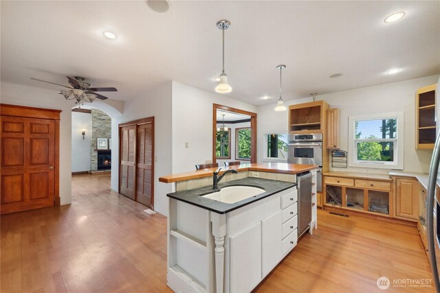 7554 Guemes Island Rd, Anacortes, WA 98221 - kitchen featuring appliances with stainless steel finishes, open shelves, a center island with sink, ceiling fan, and recessed lighting