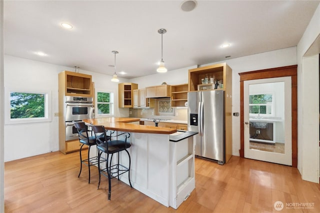 7554 Guemes Island Rd, Anacortes, WA 98221 - kitchen featuring open shelves, stainless steel appliances, light wood finished floors, a breakfast bar, and recessed lighting