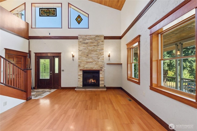 7554 Guemes Island Rd, Anacortes, WA 98221 - unfurnished living room featuring a towering ceiling, a fireplace, wood finished floors, and stairway