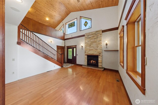 7554 Guemes Island Rd, Anacortes, WA 98221 - unfurnished living room with high vaulted ceiling, wood finished floors, a stone fireplace, stairs, and wood ceiling