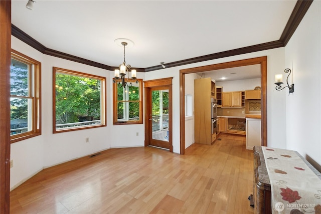 7554 Guemes Island Rd, Anacortes, WA 98221 - unfurnished dining area with a chandelier, light wood-style floors, and crown molding