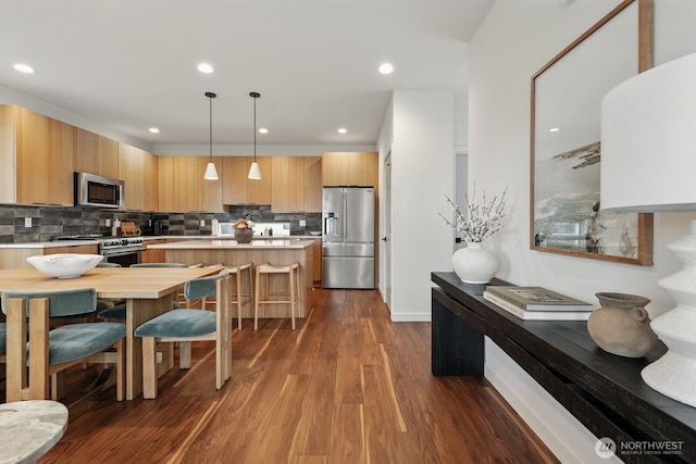 4119 Wallingford Ave N Unit C, Seattle, WA 98103 - kitchen with appliances with stainless steel finishes, light countertops, modern cabinets, dark wood-style floors, and backsplash
