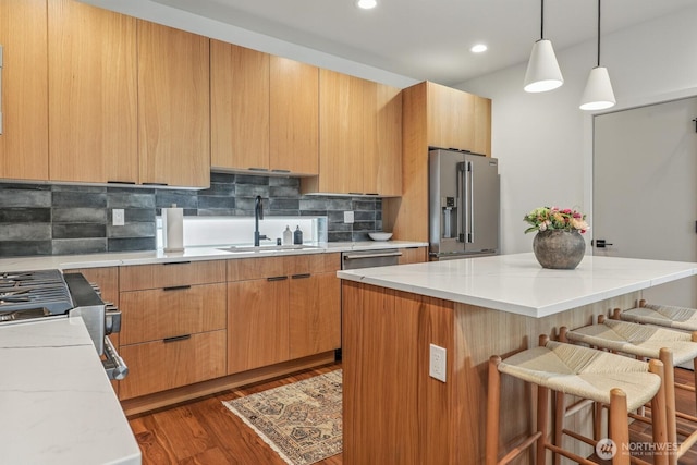 4119 Wallingford Ave N Unit C, Seattle, WA 98103 - kitchen with appliances with stainless steel finishes, a breakfast bar area, dark wood finished floors, backsplash, and a kitchen island