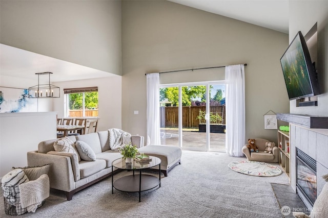 6713 135th E, Puyallup, WA 98373 - living area featuring a tiled fireplace, high vaulted ceiling, carpet floors, and a chandelier