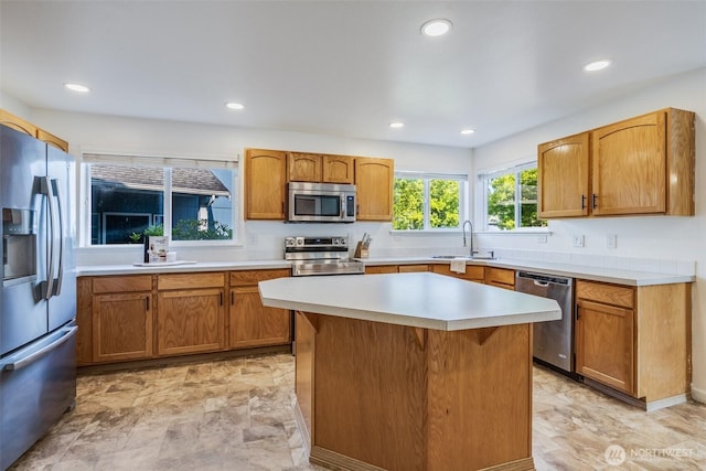 6713 135th E, Puyallup, WA 98373 - kitchen with appliances with stainless steel finishes, light countertops, recessed lighting, a kitchen island, and brown cabinets