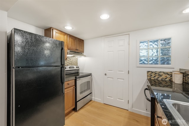 1222 6th Ave N, Seattle, WA 98109 - kitchen featuring freestanding refrigerator, stainless steel range with electric stovetop, under cabinet range hood, light wood finished floors, and dark countertops