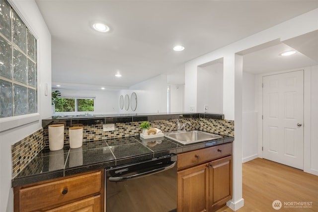 1222 6th Ave N, Seattle, WA 98109 - kitchen featuring black dishwasher, brown cabinets, light wood finished floors, tasteful backsplash, and recessed lighting