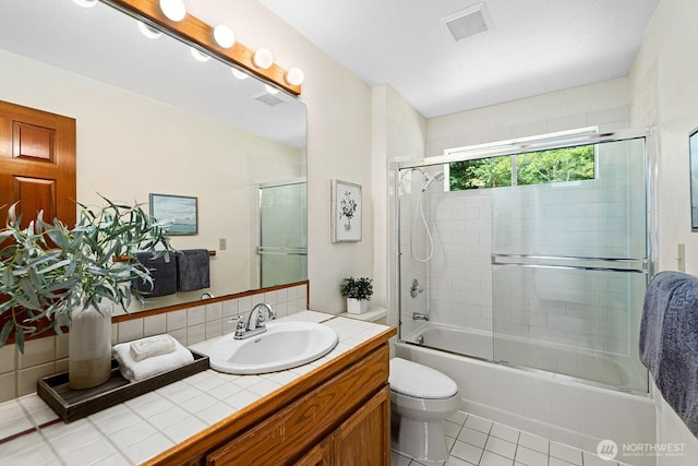 16909 NE 37th Pl, Bellevue, WA 98008 - bathroom with vanity, combined bath / shower with glass door, tile patterned flooring, and decorative backsplash