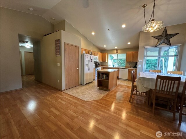 15015 105th Ave SE, Yelm, WA 98597 - kitchen featuring white appliances, light countertops, light wood-type flooring, high vaulted ceiling, and a center island