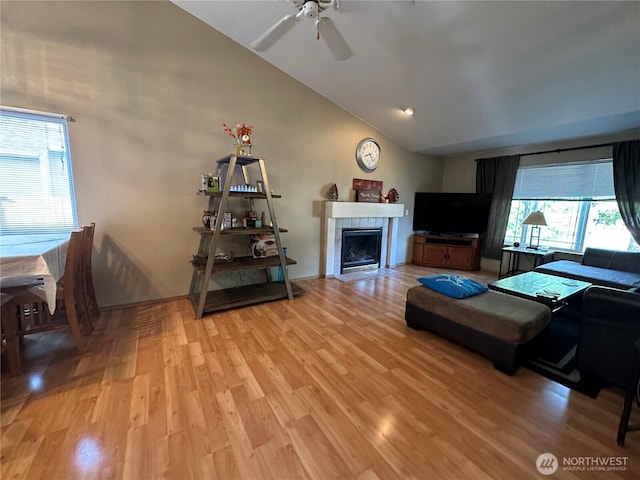 15015 105th Ave SE, Yelm, WA 98597 - living area featuring light wood-type flooring, a tiled fireplace, a ceiling fan, and high vaulted ceiling