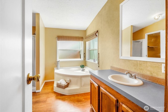 101 E 8th St, Lind, WA 99341 - full bathroom with vanity, wood finished floors, a bath, a textured ceiling, and a shower with shower door