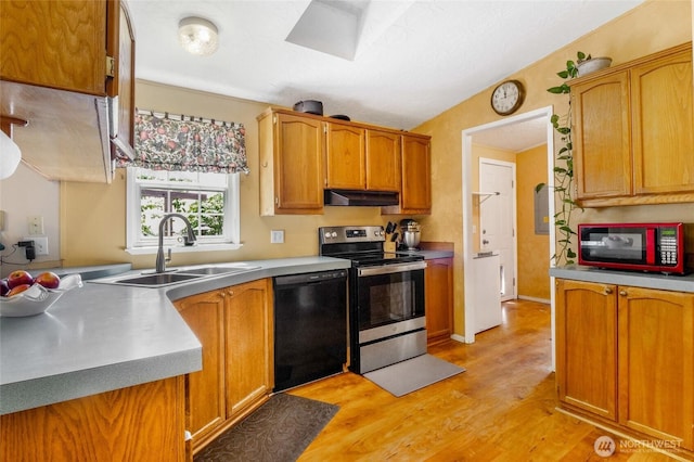 101 E 8th St, Lind, WA 99341 - kitchen with stainless steel range with electric cooktop, black dishwasher, under cabinet range hood, light wood finished floors, and brown cabinetry