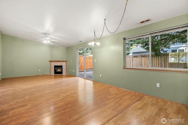 3117 243rd Street Ct E, Spanaway, WA 98387 - unfurnished living room featuring ceiling fan, plenty of natural light, a tile fireplace, and wood finished floors