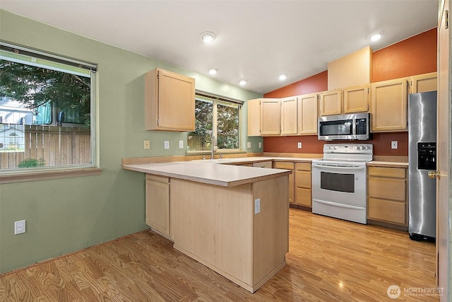 3117 243rd Street Ct E, Spanaway, WA 98387 - kitchen featuring appliances with stainless steel finishes, light brown cabinets, light wood-style floors, light countertops, and lofted ceiling