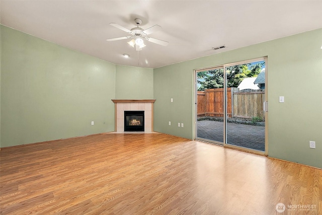 3117 243rd Street Ct E, Spanaway, WA 98387 - unfurnished living room with wood finished floors, a ceiling fan, and a fireplace