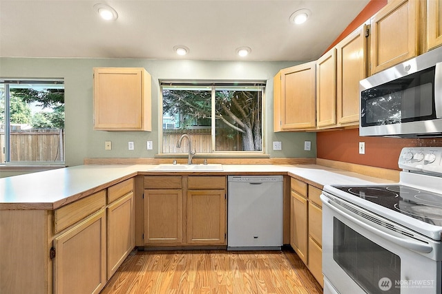 3117 243rd Street Ct E, Spanaway, WA 98387 - kitchen with white appliances, light countertops, light brown cabinets, a peninsula, and recessed lighting