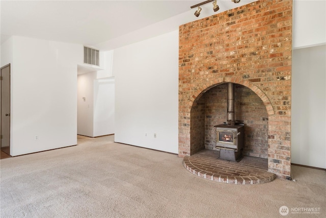 18552 15th Loop NE, Poulsbo, WA 98370 - unfurnished living room featuring carpet floors and a wood stove