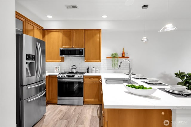 7549 SE 29th St Unit 301, Mercer Island, WA 98040 - kitchen with stainless steel appliances, brown cabinetry, tasteful backsplash, light wood-style floors, and recessed lighting