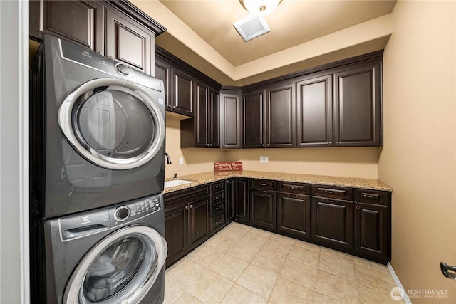 2014 Parkview Dr NE, Tacoma, WA 98422 - washroom featuring cabinet space, stacked washing machine and dryer, and light tile patterned flooring
