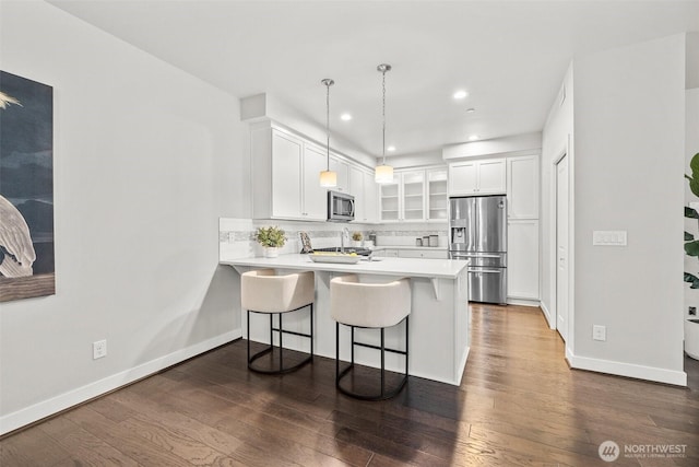 15791 NE 114th Way, Redmond, WA 98052 - kitchen with stainless steel appliances, glass insert cabinets, a peninsula, white cabinetry, and backsplash